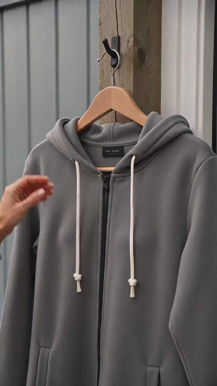 Kort film som visar långlinjig huvjacka med dragkedja i mjuk stickad fleece i rörelse — passform, material och detaljer.