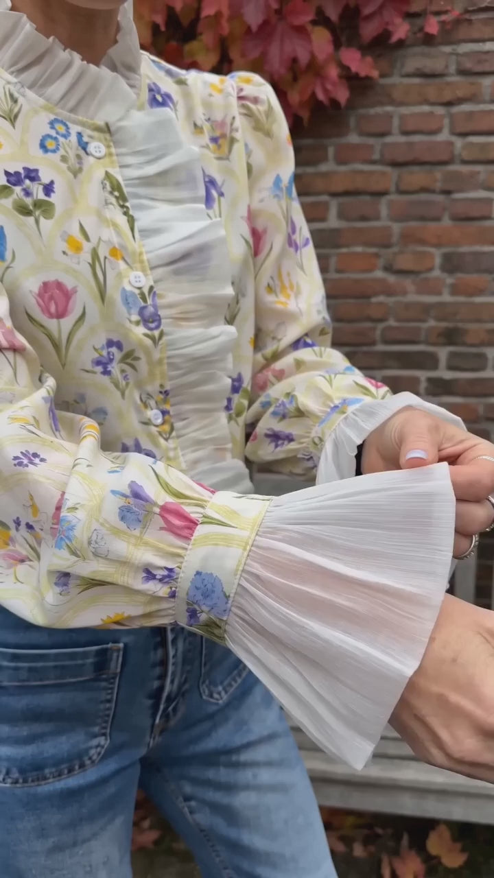 Kort film som visar elegant höstblus med polokrage och volanger i rörelse — passform, material och detaljer.
