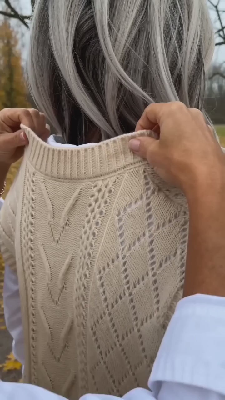 Kort film som visar kabelstickad väst med v-ringning i rörelse — passform, material och detaljer.