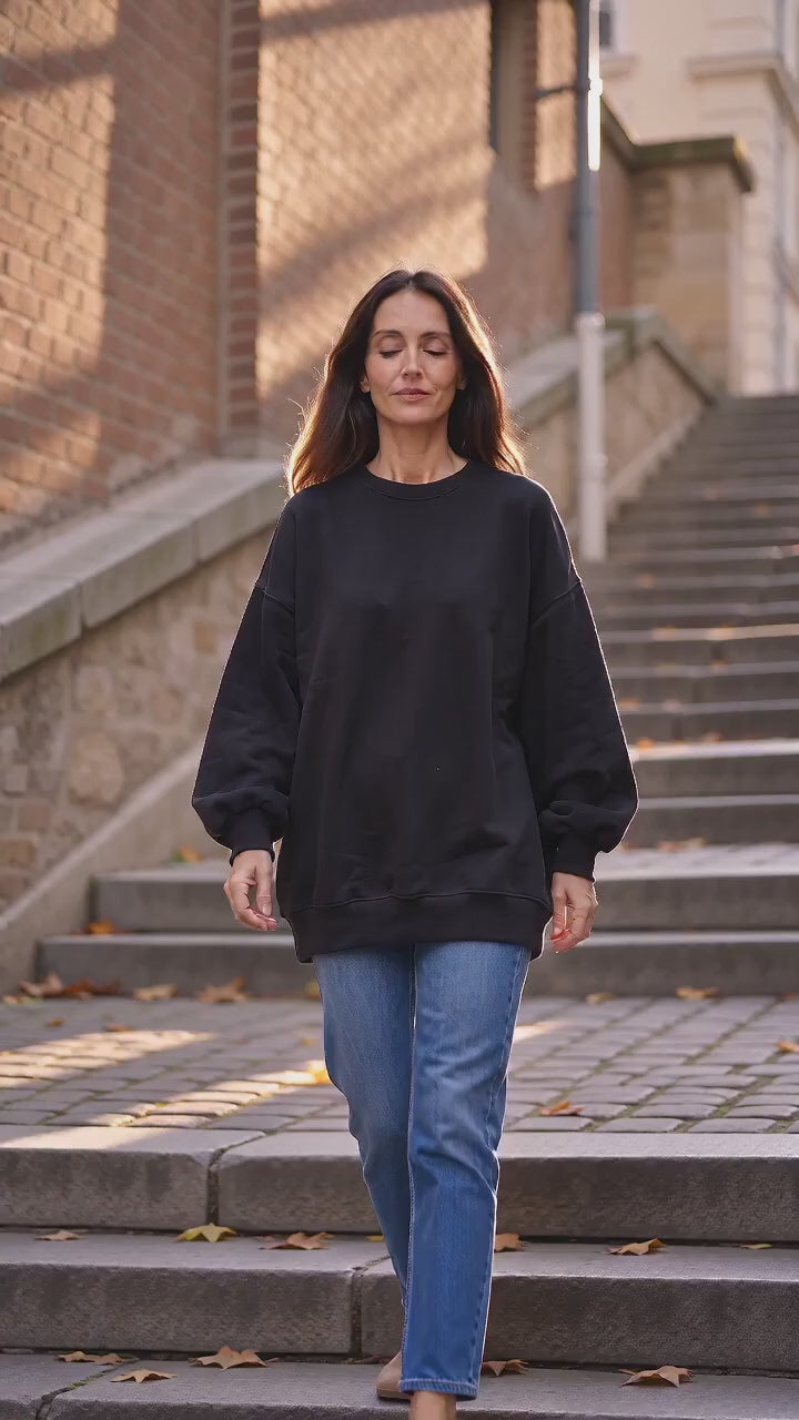Videoannons: kvinna i svart oversized sweatshirt med mjuk akrylblandning, höstpromenad