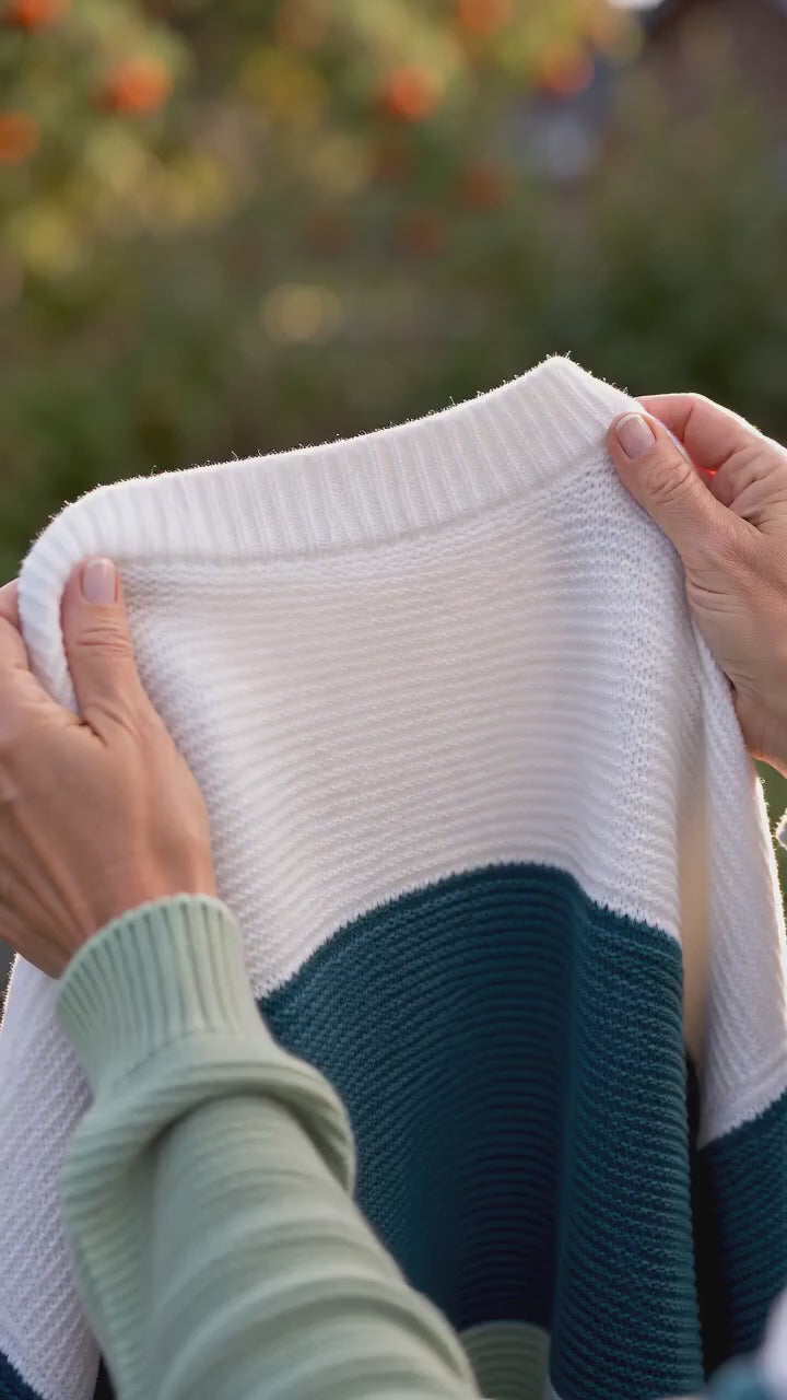 Kort film som visar stickad dam tröja med trifärgad patchwork design i rörelse — passform, material och detaljer.