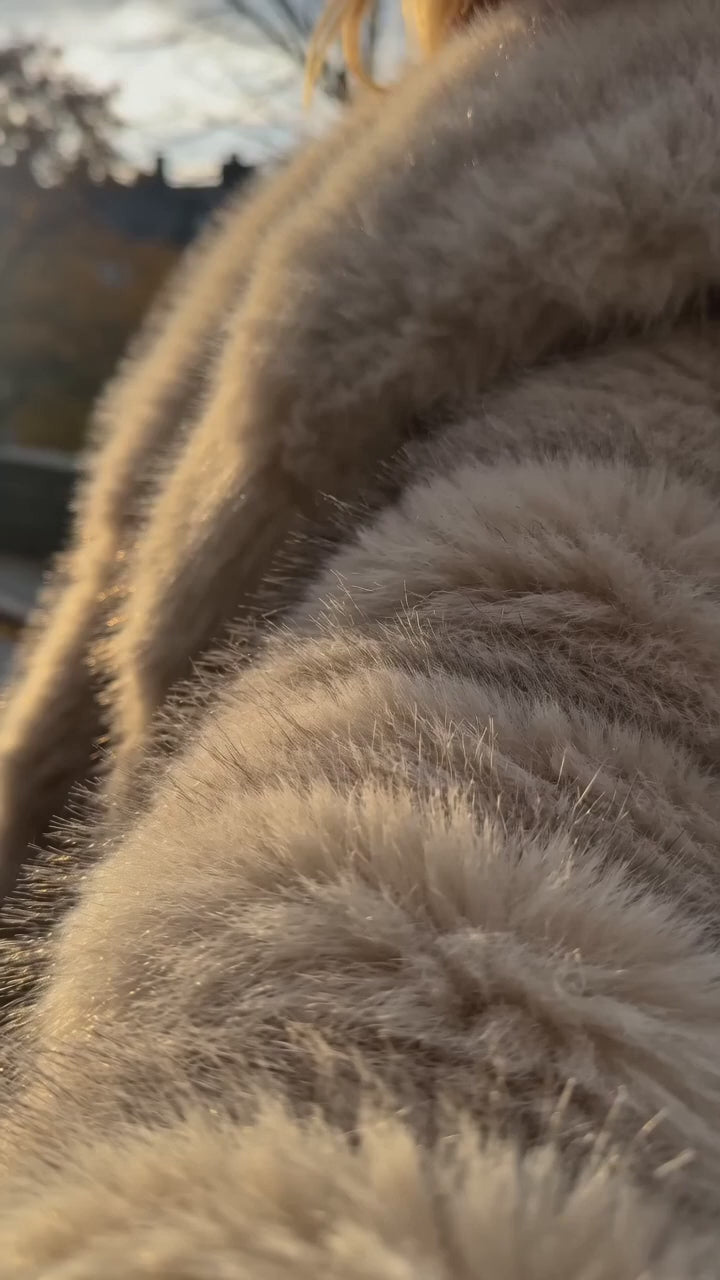 Långlinjekappa i fuskpäls – oversized beige kappa buren utomhus