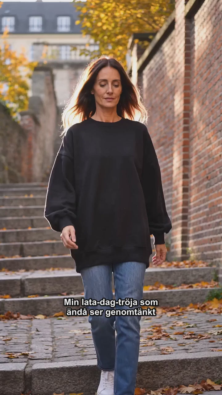 Videoannons: kvinna i svart oversized stickad tröja utan sidöppningar, höst