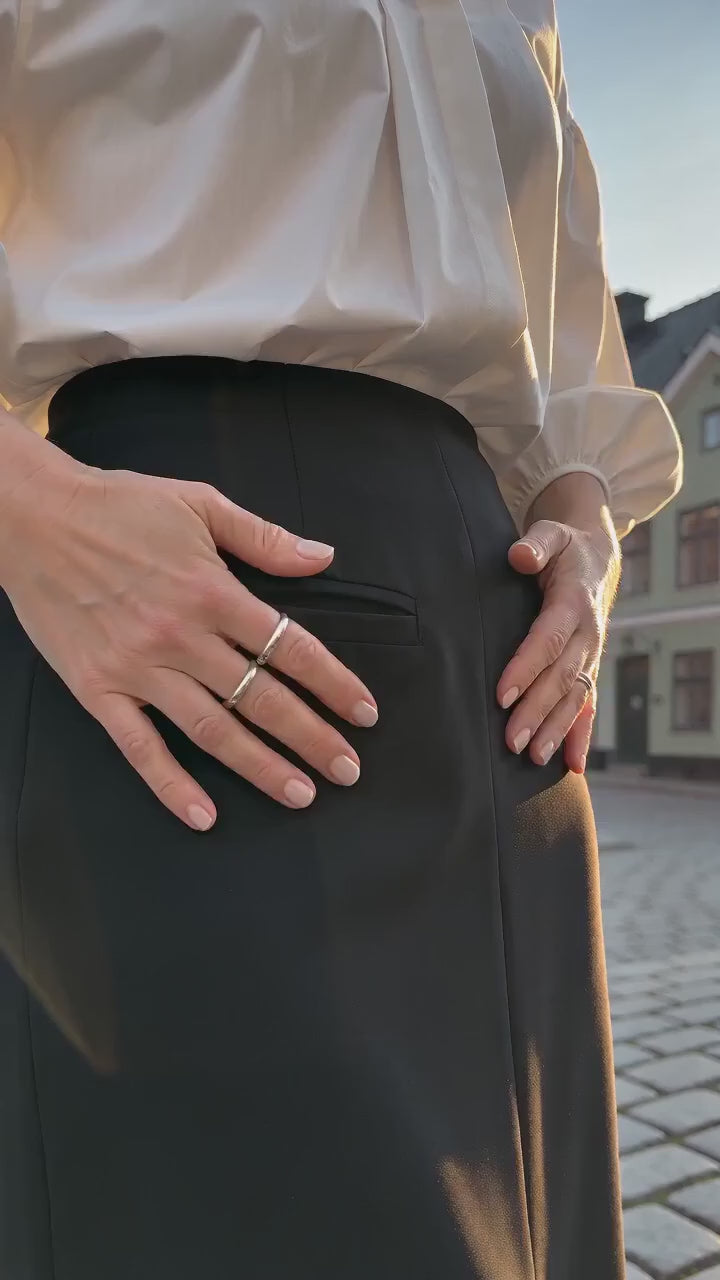 Kort film som visar elegant lång kostymkjol med slits för vårens stilar i rörelse — passform, material och detaljer.